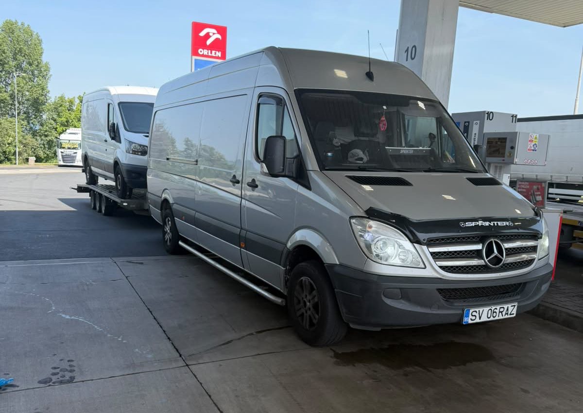 Duba Mercedes Sprinter RazTrans cu platformă auto încărcată, la o benzinărie